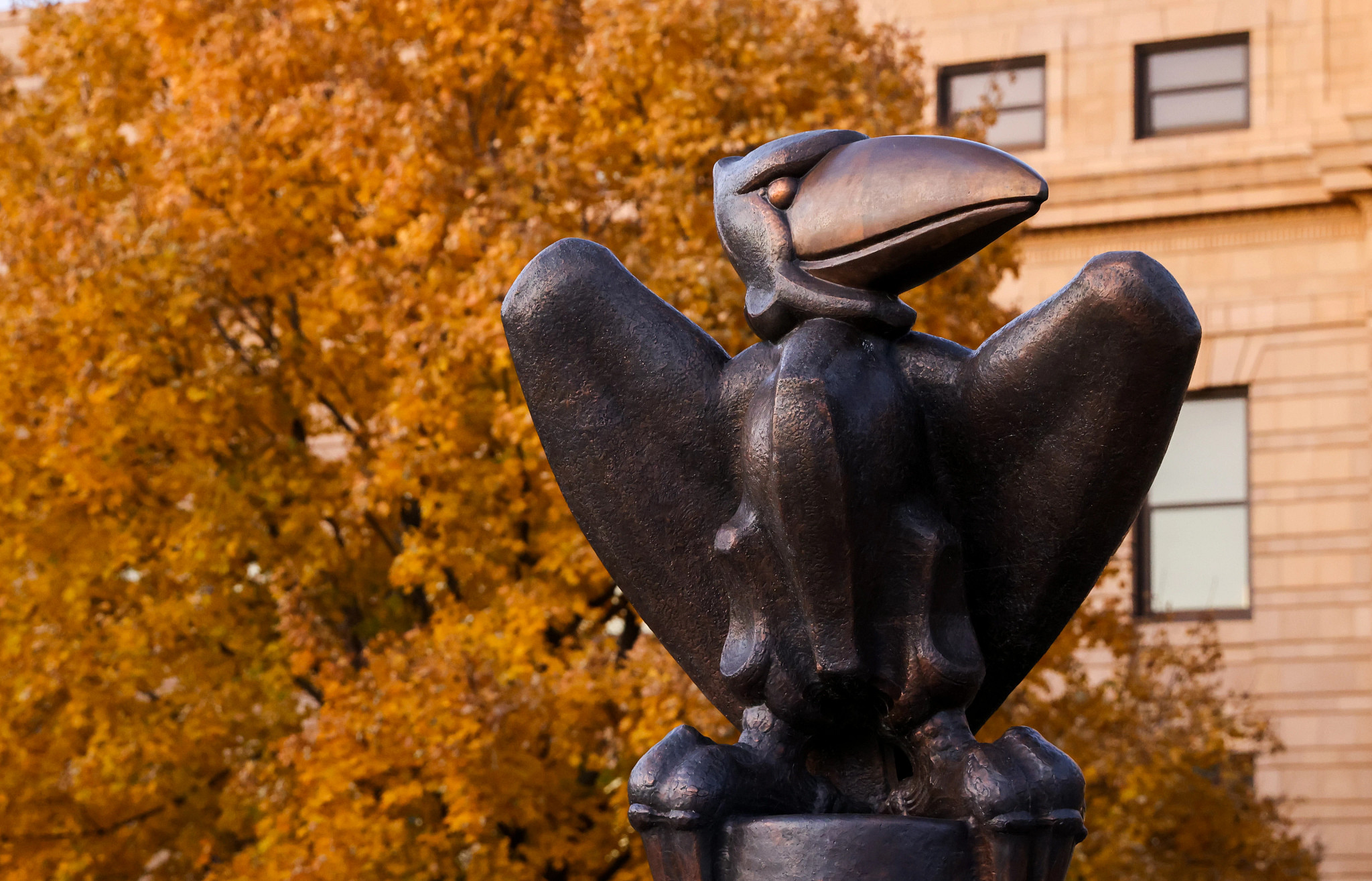 Jayhawk statue with autumn foliage in the background