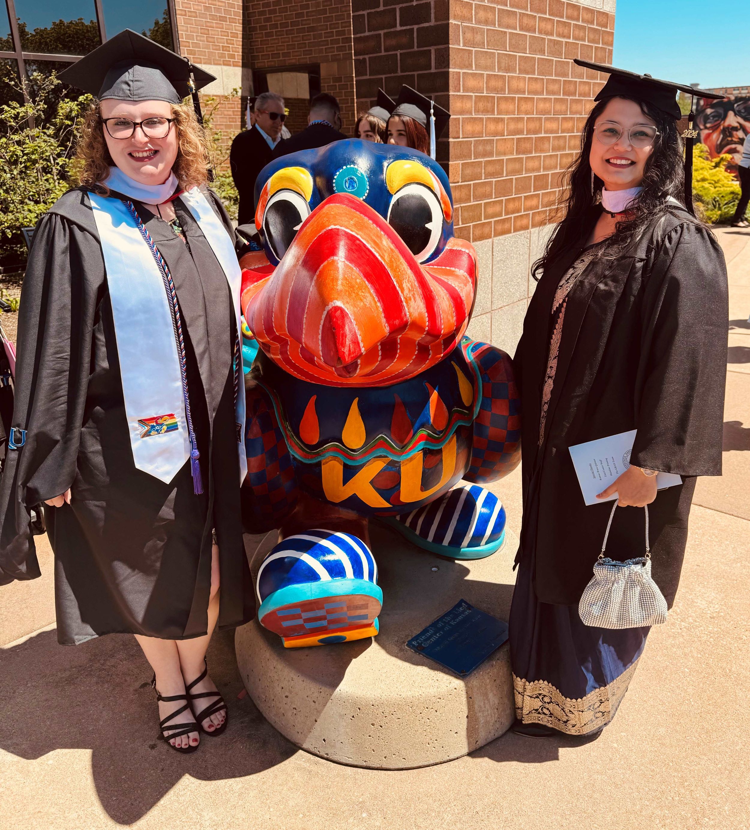 Amber and Sameen standing outside in front of a Jayhawk statue.